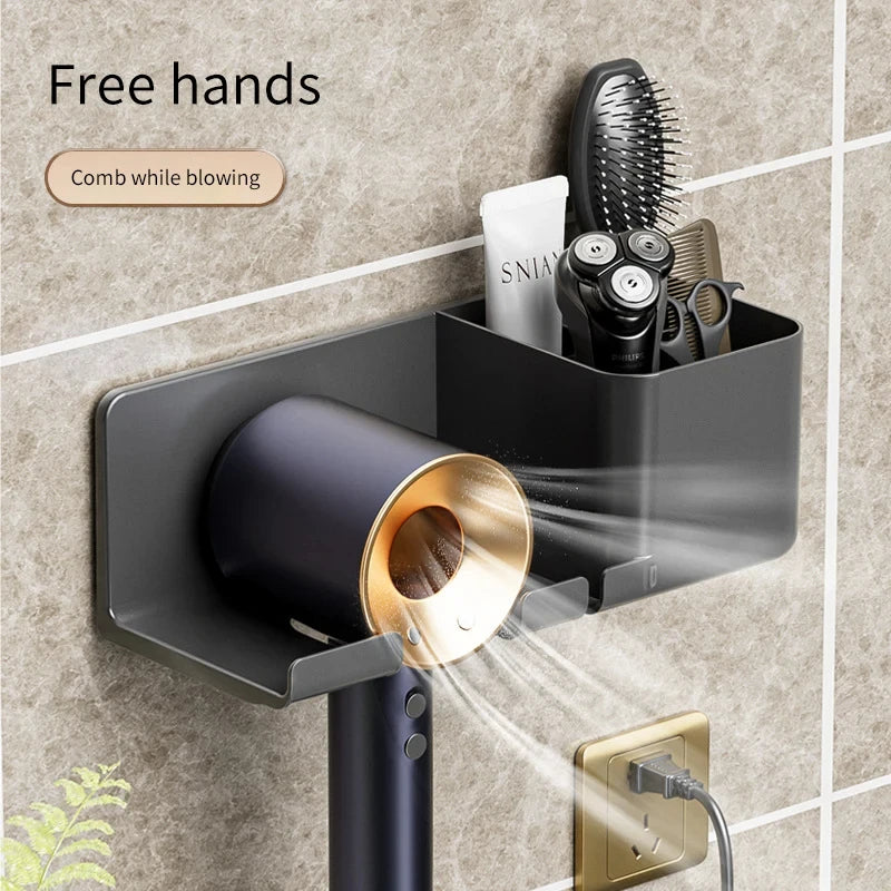 Wall-mounted hair dryer with storage compartment and 'Free hands' text on a tiled wall background.