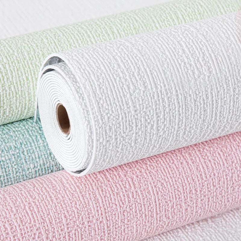 Three rolls of textured wallpaper in green, white, and pink.
