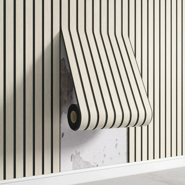 Roll of black and white striped wallpaper against a striped wall.