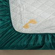 Teal fitted sheet with a stain on a mattress corner