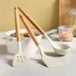 Set of kitchen utensils including a spatula and ladle on a countertop with a neutral background.