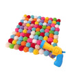 Colorful pom-pom blanket with a toy gun on a white background