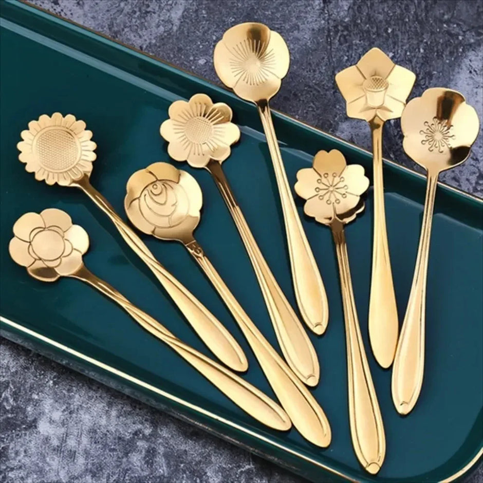 Set of gold floral spoons on a green tray with a dark textured background