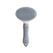 Pet grooming brush with gray bristle head and white handle on a white background