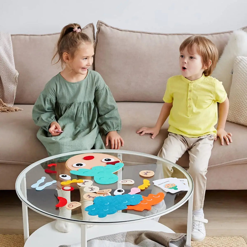 Two children playing with a puzzle on a glass table in a living room.