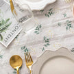 Table setting with floral tablecloth, plates, cutlery, and a magazine.