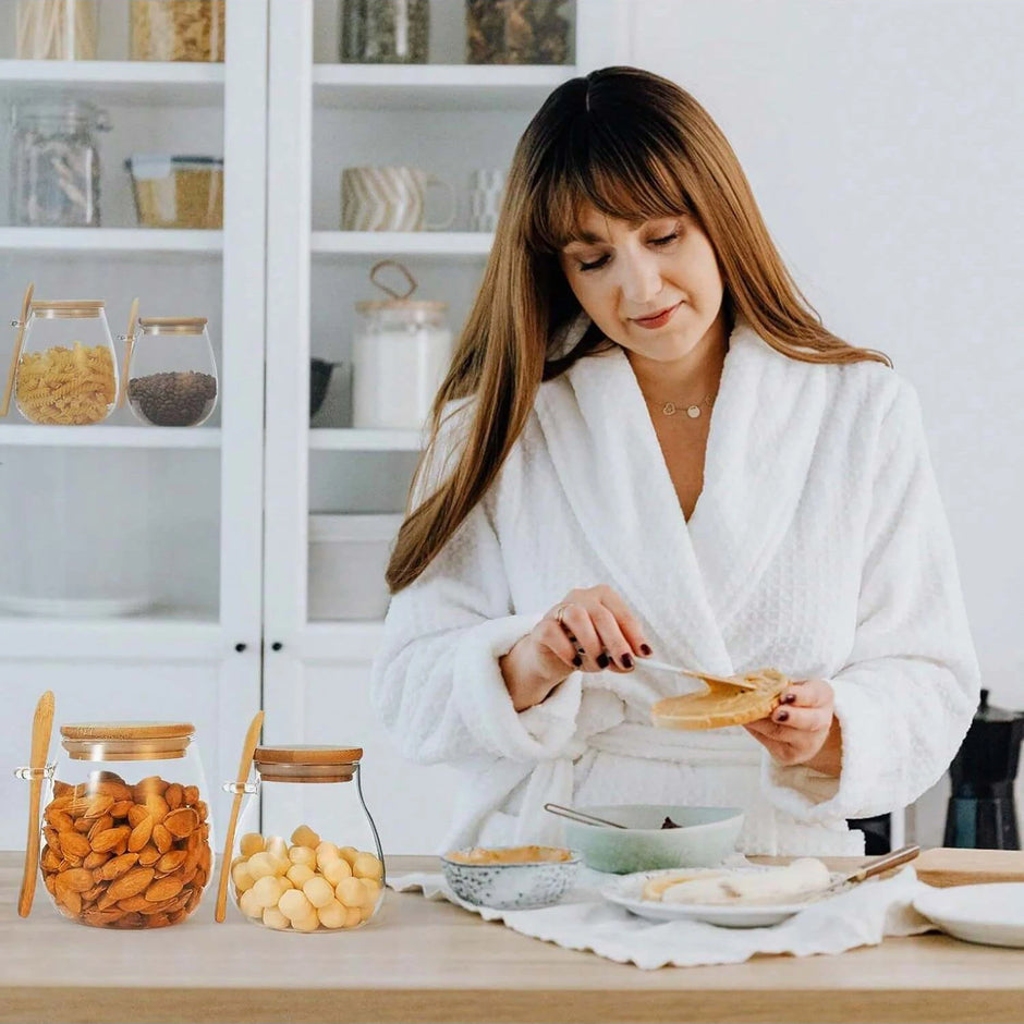 Woman in a white robe preparing food in a kitchen.