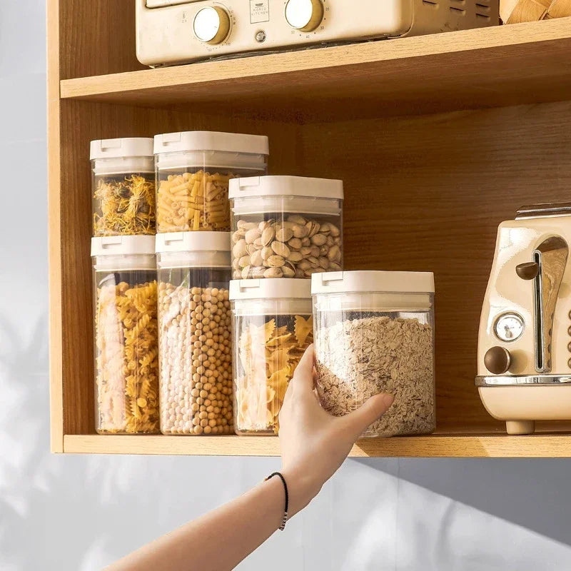 Hand reaching for a container of oats on a wooden shelf with other food containers.