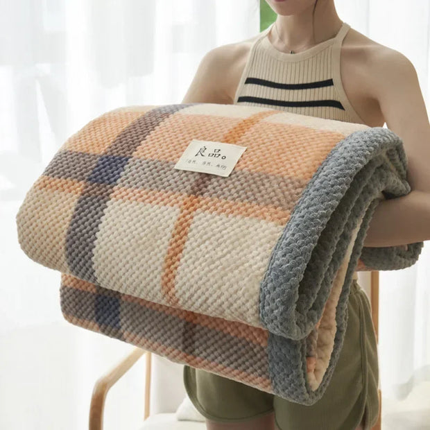 Person holding a checkered blanket with a visible brand label against a light background