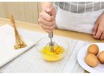 Person whisking eggs in a bowl with a whisker on a kitchen counter.