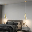 Modern bedroom with gray walls, a bed, and two gold pendant lights.