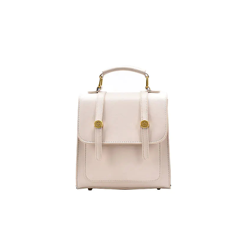 Small beige handbag with gold accents on a white background